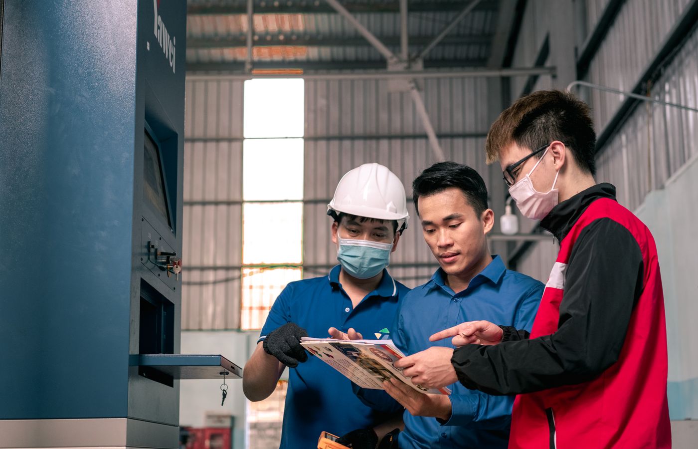 Two workers going over plans on a warehouse floor